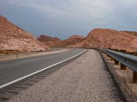 the paved highway has several curves along the middle of it on both sides of it is a few hills