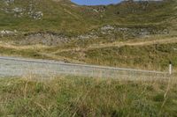 a red and white sign is on the side of a hill next to a road