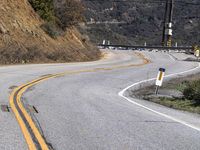 a sign directing drivers to go to and exit the road while traffic is down a hill