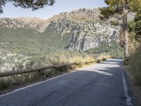 a paved road running beside a mountain on a sunny day in the mountains near marseille