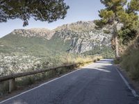 a paved road running beside a mountain on a sunny day in the mountains near marseille