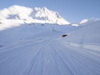 the man is skiing down the snowy mountain side trail in the back ground, blurred with motion