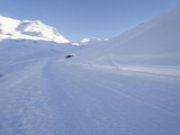 the man is skiing down the snowy mountain side trail in the back ground, blurred with motion