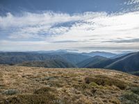 the view from the top of a mountain overlooking mountains and valleys in the background is an empty field