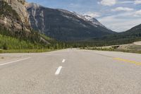 a man with backpack on a mountain road in the mountains in canada's alberta national park