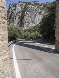 a person with backpack on the side of a road next to some trees and mountains