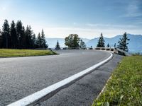 the winding road is surrounded by pine trees on a mountain side near the ocean shore