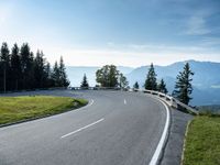 the winding road is surrounded by pine trees on a mountain side near the ocean shore