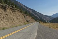 a scenic mountain road with steep hillsides on both sides of it and trees all around