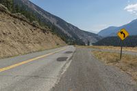 a scenic mountain road with steep hillsides on both sides of it and trees all around