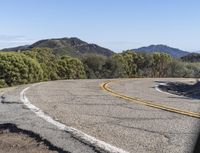 the asphalt on the road is yellow and gray in color, along with other areas of forest