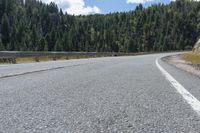 the view from the side of a mountain road with a motorcycle parked at the corner