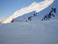 a skier stands on the slope in front of snowy mountains while it's not sunny