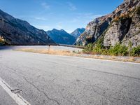 the curved road on the side of a mountainside with trees in front of it