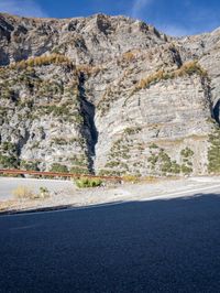a red motorcycle driving down a highway past a canyon side road and mountains at the same height