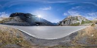 a car is parked at the end of a curve in a mountainous road in the mountains