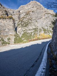 a lone bike parked on the side of a hill near a steep cliff next to a road