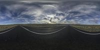 an open road with two lanes extending into the horizon, with clouds hovering from top