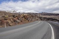 the curve of a mountain road in the country side has a few snow on top