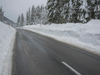 a snowy road in the winter with trees and snow on both sides of it and trees covered in snow