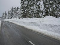 a snowy road in the winter with trees and snow on both sides of it and trees covered in snow