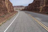 a mountain road with a cliff behind it and no traffic as if going by or riding