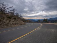 the road is empty and ready for cars to go on it's way into the mountains