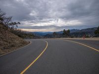 the road is empty and ready for cars to go on it's way into the mountains