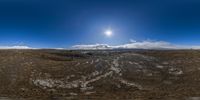 a view of the sun from an upside down lens on a mountain slope in a flat landscape