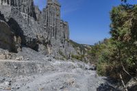 the cliff is tall and has a steep cliff face that looks very high up in the sky