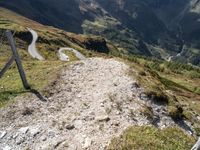 a trail that is going through a mountainous area in mountains with snowcapped peaks