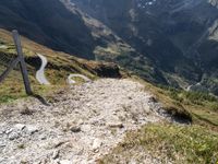 a trail that is going through a mountainous area in mountains with snowcapped peaks