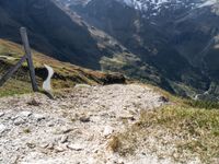 a trail that is going through a mountainous area in mountains with snowcapped peaks