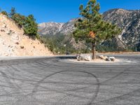 the empty parking lot at the base of a mountain trail in california, usa and an asphalt road near it