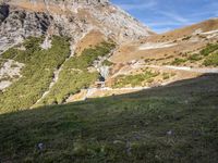 a man standing in a valley with the mountains in the background taking a picture of his dog