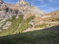 a man standing in a valley with the mountains in the background taking a picture of his dog