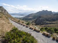 an old mountain road curves along a valley in the desert, near mountains and ocean