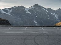 a car is in a car park with mountains behind it in the distance from which it is located