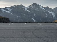 a car is in a car park with mountains behind it in the distance from which it is located