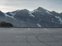 a car is in a car park with mountains behind it in the distance from which it is located