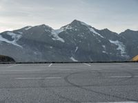 a car is in a car park with mountains behind it in the distance from which it is located