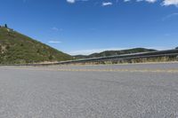 the road that goes around and into the mountains has a curved road along it with the mountain on one side