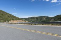 the road that goes around and into the mountains has a curved road along it with the mountain on one side