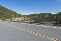 the road that goes around and into the mountains has a curved road along it with the mountain on one side