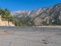 a fire hydrant on the side of a road with mountains in the distance on the other side