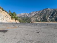 a fire hydrant on the side of a road with mountains in the distance on the other side