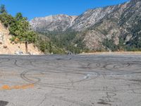 a fire hydrant on the side of a road with mountains in the distance on the other side