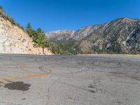 a fire hydrant on the side of a road with mountains in the distance on the other side