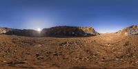 the sun is shining above the mountains as if in a 360 angle view from a fisheye lens