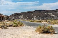 the road stretches into a large mountainous, barren area in the desert area of the deserts